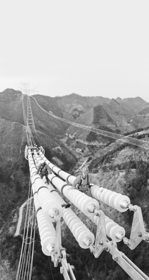 银色巨龙越秦岭――昌吉―古泉特高压陕3标段建设现场走笔　　施工人员在导线上作业。 　　开栏的话：从千里沃野到莽莽群山，从东海之滨到天山脚下，一基基铁塔拔地而起，一条条银线伸向远方，电能为决胜全面建成小康社会注入强劲的动力
