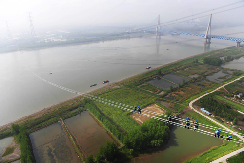 				准东—皖南特高压长江大跨越工程现场。　　4月15日，在安徽省无为县高沟镇长江北岸，一排排导线在张力机作用下缓缓向长江南岸牵引场释放