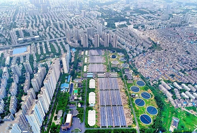 　　从空中俯瞰，王小郢污水处理厂好似一面巨大的镜子，格外亮眼，其上覆盖的太阳能电池板将太阳能源源不断转化成电能，供应厂区用电需求。　　王小郢污水处理厂分布式光伏发电，成为全国单体规模最大，安徽省建成投产的污水处理厂光伏项目