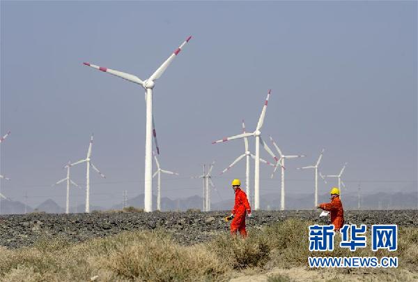 　　在乌鲁木齐近郊的达坂城风力发电场，两位工作人员在巡检风力发电设备（9月18日摄）。 进入秋季，新疆风电、光伏发电量和利用小时持续提升