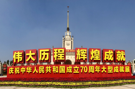 9月24日一早，金色的阳光洒在北京展览馆，“伟大历程辉煌成就——庆祝中华人民共和国成立70周年大型成就展”首日向公众开放。大门两侧，“紧密团结在以习近平同志为核心的党中央周围为实现中华民族伟大复兴不懈奋斗”的标语格外引人注目。