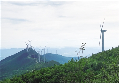 绵延数里的山峦上，一台台标有“中国华能”的风机如“定海神针”般矗立于苍穹之下，错落有致、生机盎然，它们带来绿色电力的同时，也成为了当地一道亮丽的风景线。